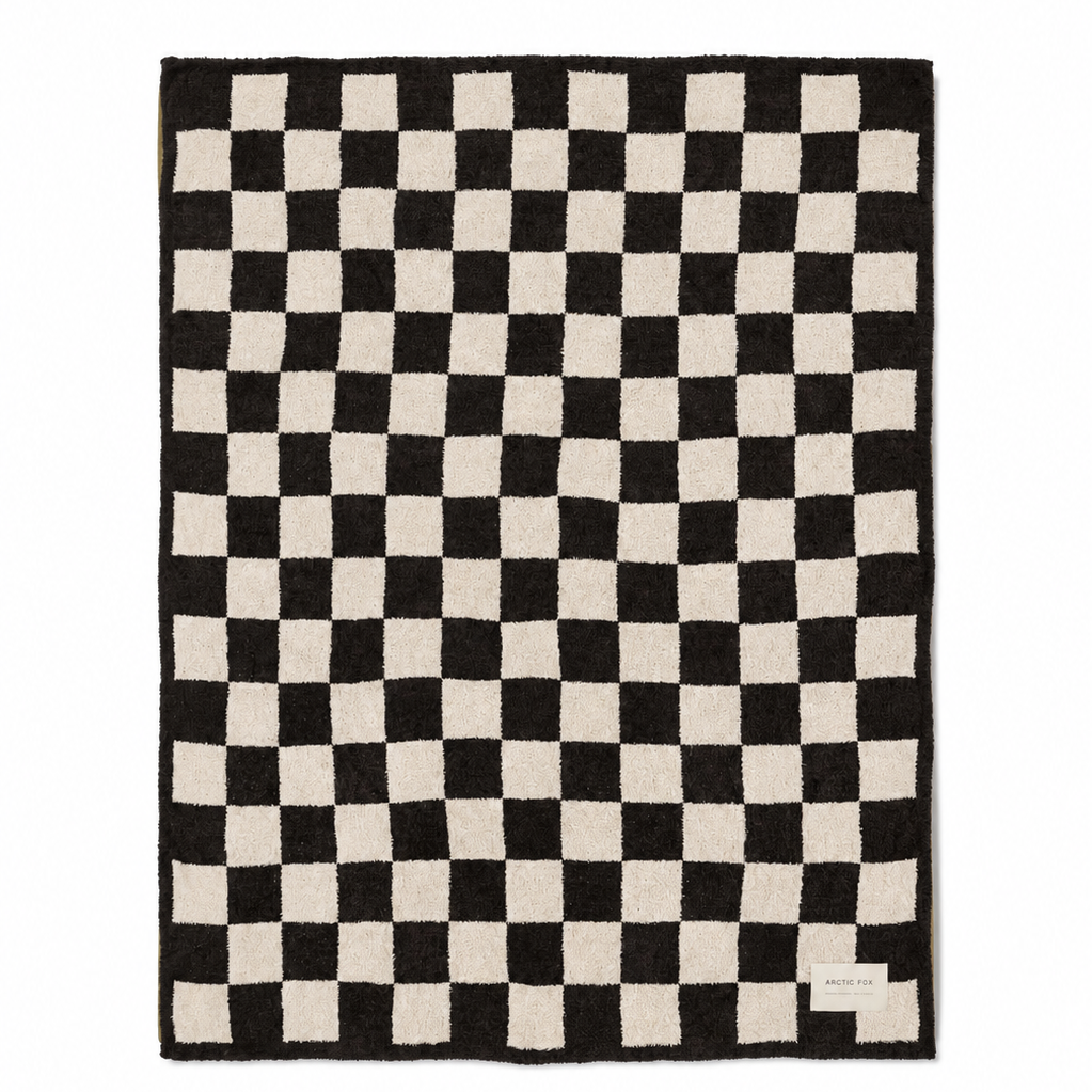 A rectangular area rug with a black and off-white checkerboard pattern, shown flat against a solid white background.