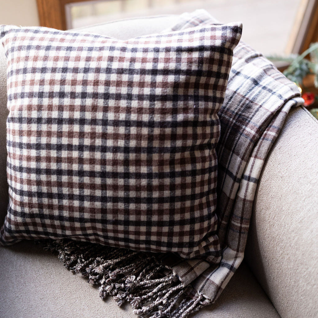 brown and black plaid reversible pillow with matching blanket on chair