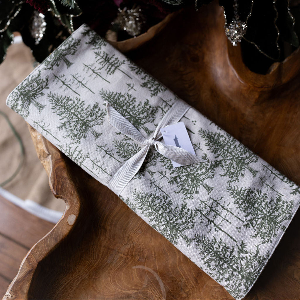 Evergreen tree table runner with bow on wood table