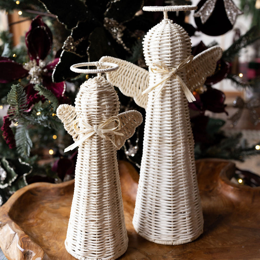 Two rattan angels on a wood table
