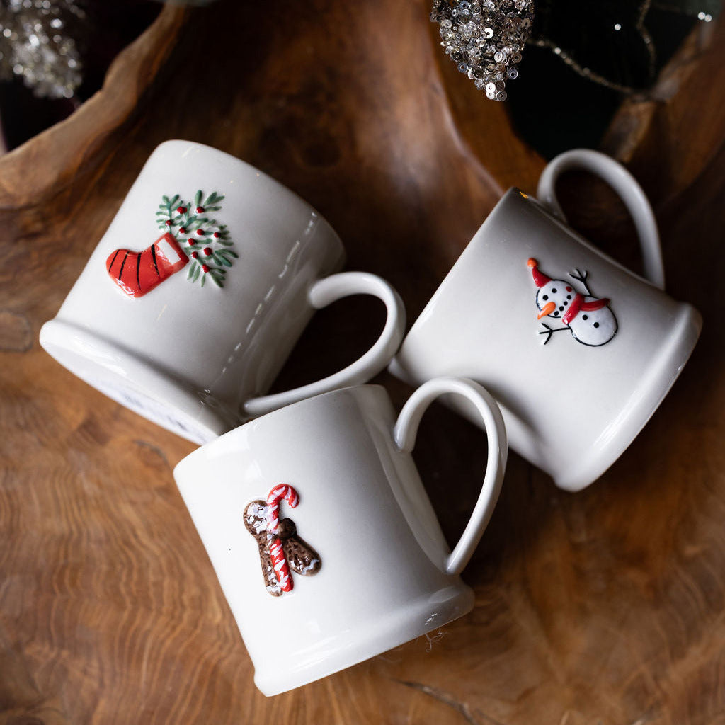 3 stoneware 8  oz mugs with a stocking, snowman or gingerbread man on a wood table