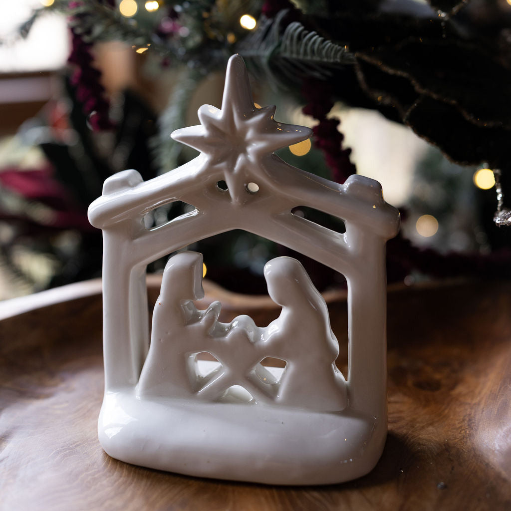 white ceramic nativity scene on wood table